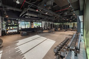 A gym with weightlifting equipment, treadmills, and exercise machines. - Modern Studio with Canal Views in Peninsula Two (Dubai)