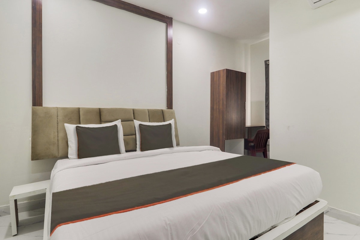Ein Hotelzimmer mit Bett, Nachttisch und Kleiderschrank.