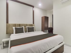 Ein Hotelzimmer mit Bett, Nachttisch und Kleiderschrank.