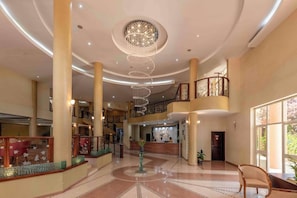 Eine geräumige Lobby mit einer zentralen Wendeltreppe, mehreren Etagen und einer Rezeption.