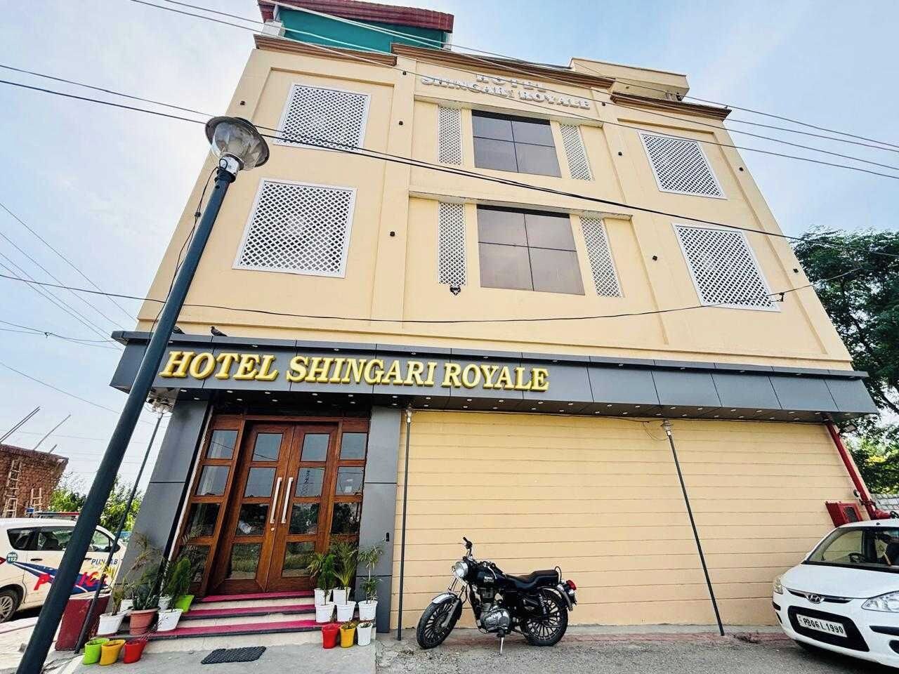 A hotel named 'Hotel Shingari Royale' with a large entrance and a motorcycle parked in front.