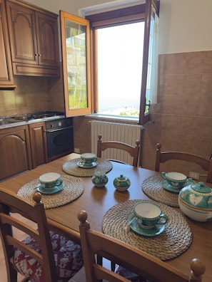A dining area with a wooden table set for tea, surrounded by wooden chairs. - Villa Horizon - Sky & Sea Terrace (Amalfi)