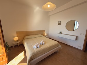A bedroom with a bed, bedside lamps, a round mirror, and a small shelf. - Villa Horizon - Sky & Sea Terrace (Amalfi)