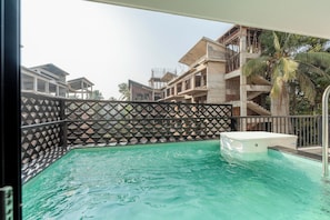 A swimming pool with a hot tub, surrounded by a fence with a geometric pattern. - Staymaster Avtara - Serviced Apartments (Calangute)