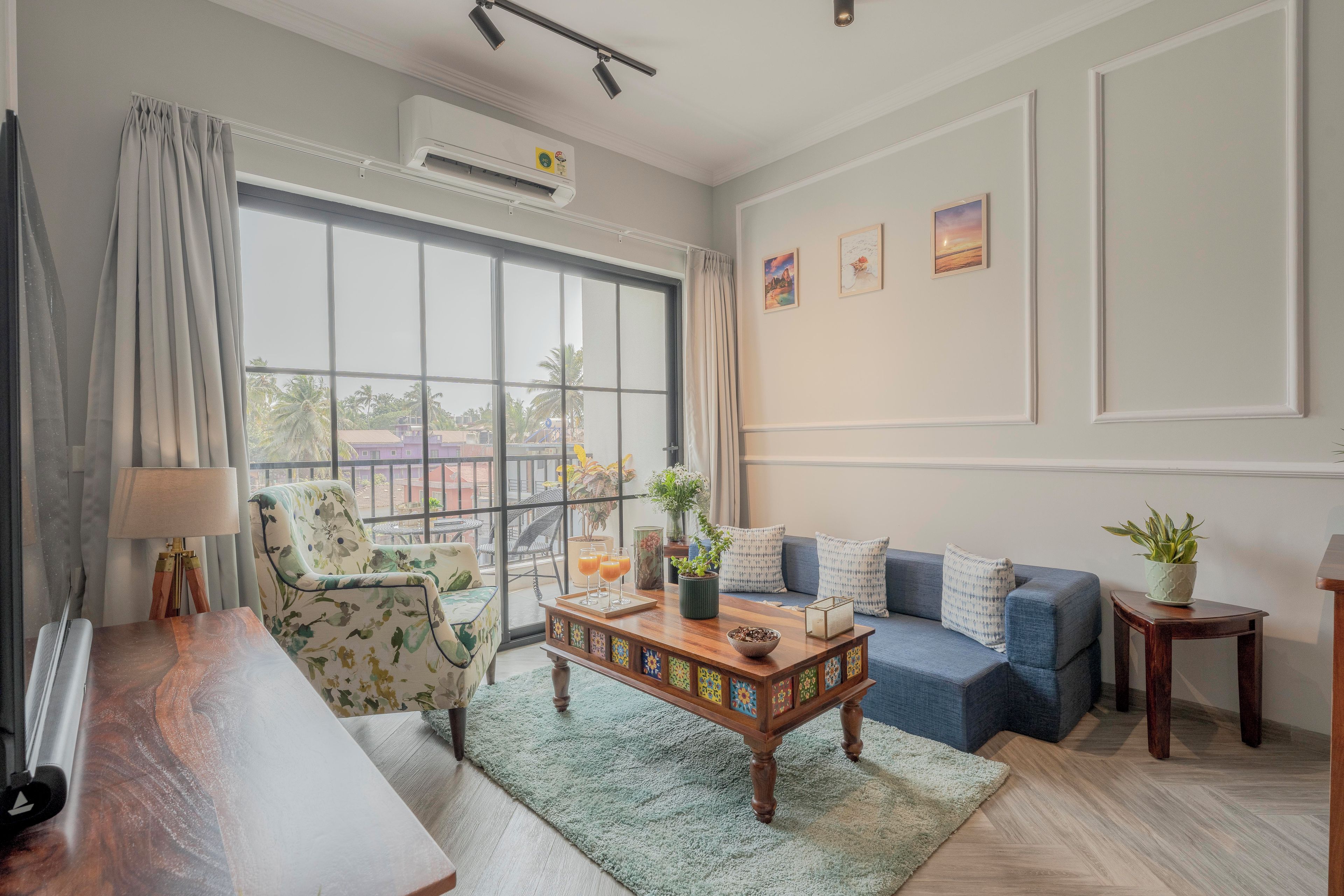 Un salon avec un canapé, un fauteuil et une table basse sur laquelle sont posées des boissons.