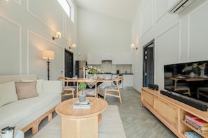 A modern living room with a sofa, coffee table, and TV stand.