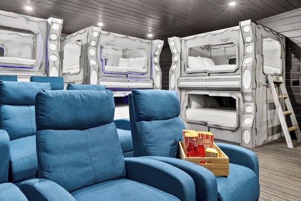 Ein Zimmer mit Etagenbetten, einem blauen Sofa und einem Tablett für Snacks.