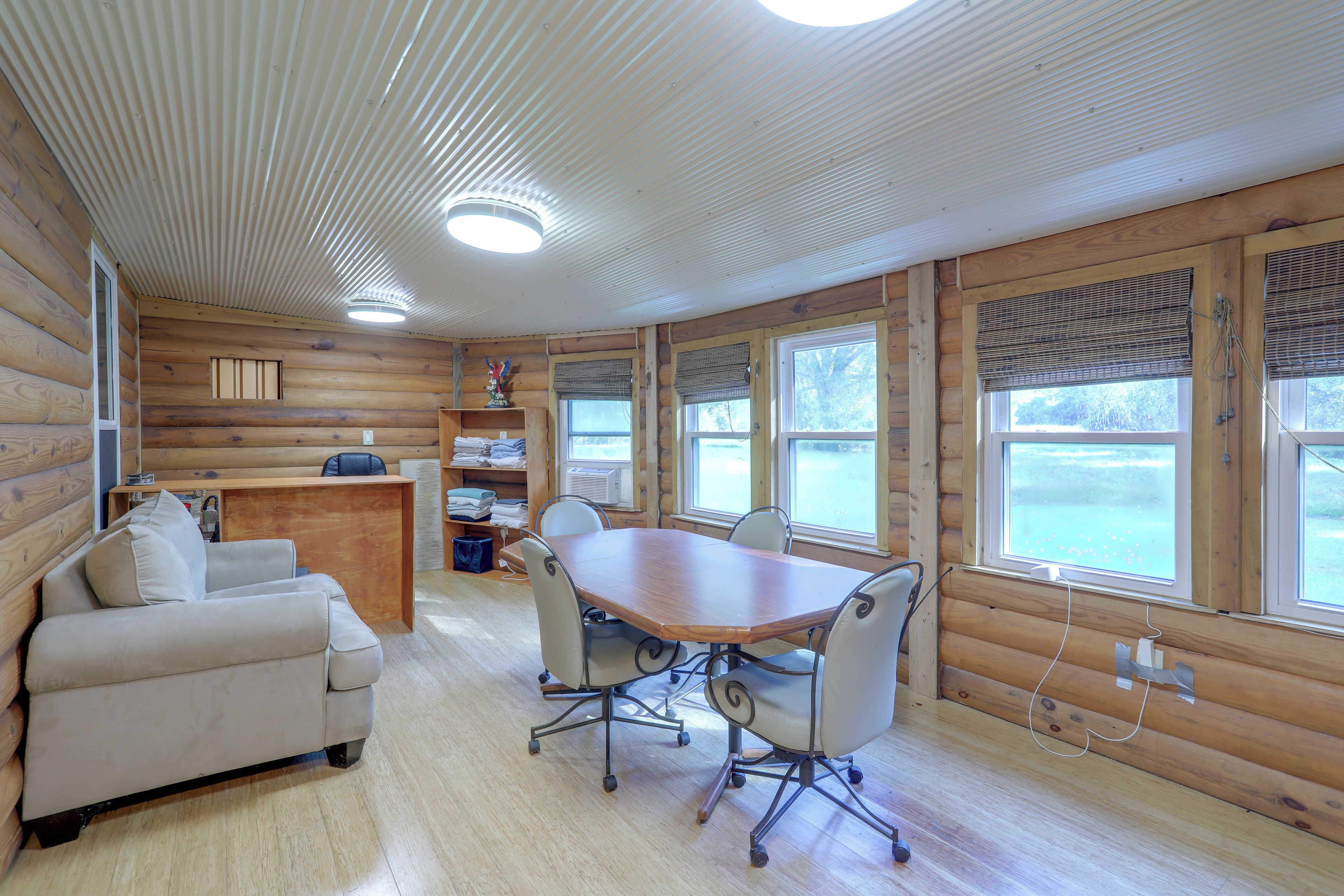 L’intérieur d’une cabine est aménagé avec du bois, il comprend une table à manger avec des chaises, un canapé et un bureau.