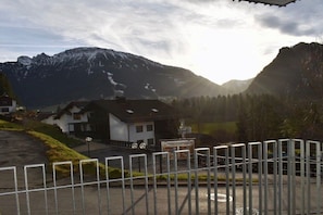 Ein begrenzter Zugang zu einem Gebäude mit Blick auf Berge, eine Beschilderung, die ein Konferenzzentrum anzeigt, und ein klarer Himmel.
