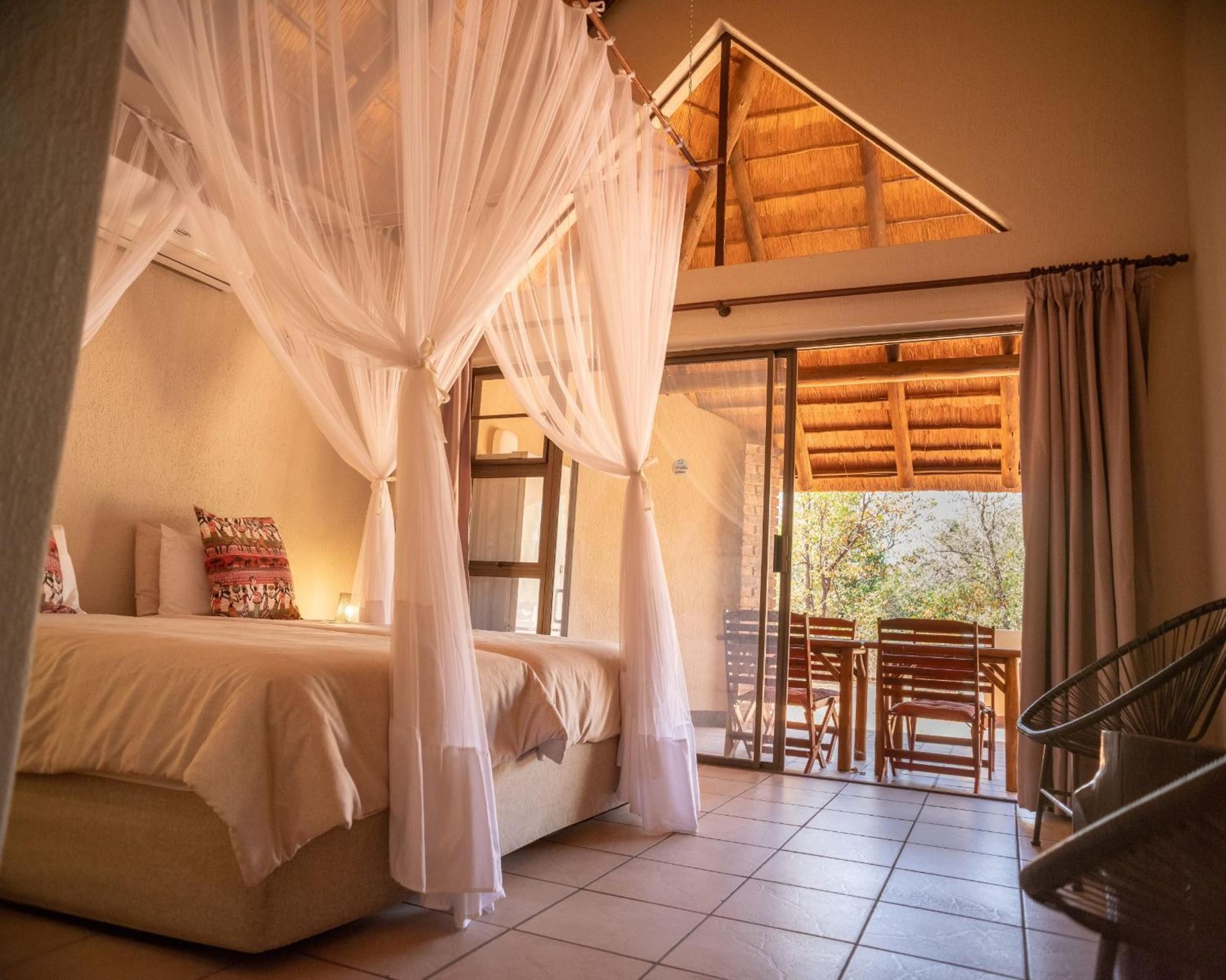 Une chambre à coucher avec un lit, un baldaquin, une fenêtre et une vue sur l’extérieur.