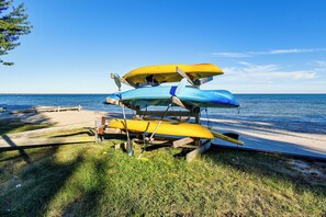 A stack of kayaks on a wooden stand by the beach. - Direct Shoreline Access! Tawas City Cabin (Tawas City)