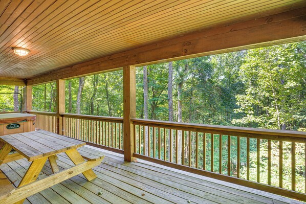 A wooden deck with a picnic table and a hot tub. - Rustic Cabin Retreat in the Peaceful Mountains (Elk Park)