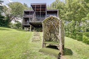 A modern two-story building with a wooden deck and a staircase leading to the upper level. - Mid-Century Modern Chateau du Coach House (Iowa City)