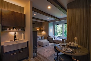 A modern interior with a kitchen, dining area, and seating space with large windows.
