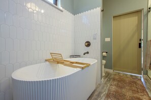 Ein modernes Badezimmer mit freistehender Badewanne, Toilette und Duschbereich.