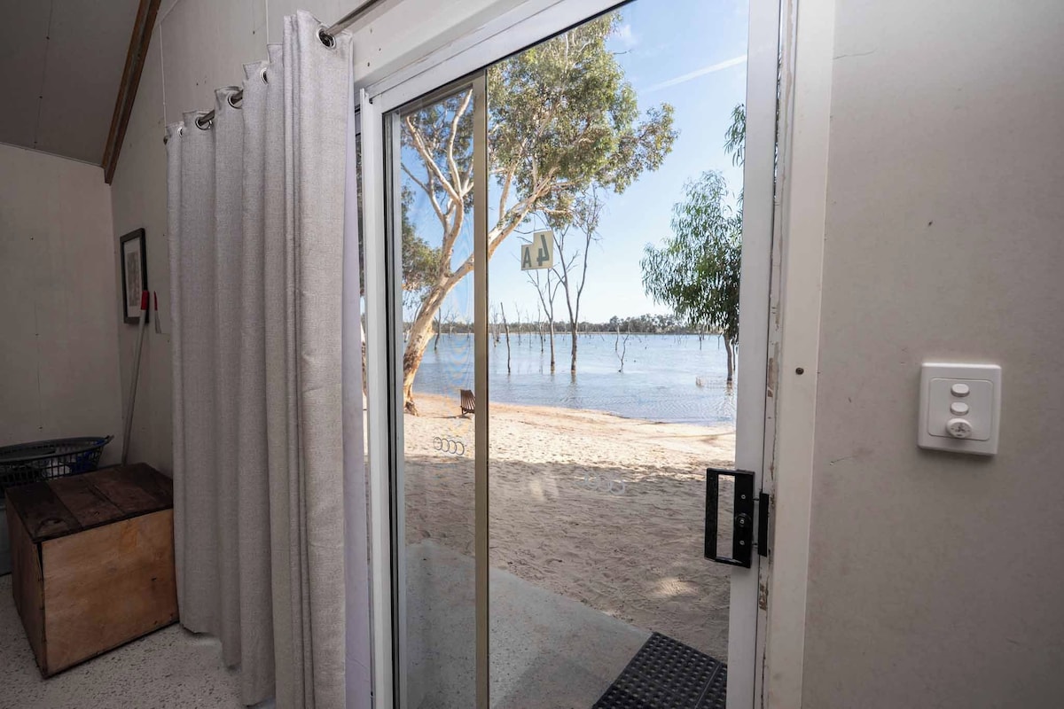 Una habitación con puerta corrediza de vidrio que da a una playa.