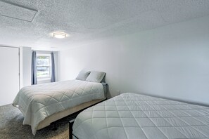 A bedroom with two beds, a window with curtains, and a ceiling light. - Lakefront Tawas City Gem w/ Gazebo & Beach Access (Tawas City)