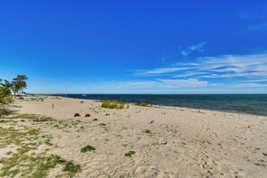 A beach with clear skies, sandy shore, and a calm sea. - Lakefront Tawas City Gem w/ Gazebo & Beach Access (Tawas City)