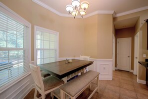 A dining area with a wooden table, white chairs, and a bench. - Near FSU & FAMU: Midway Home w/ Private Yard (Midway)