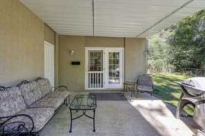 A covered patio area with a sofa, a small table, and a grill. - Quiet Horse Farm Hideaway Near Downtown Aiken (Aiken)