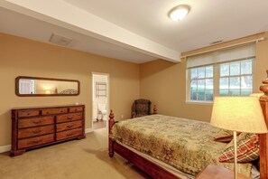 Une chambre à coucher avec un lit, une commode, un miroir et une fenêtre.