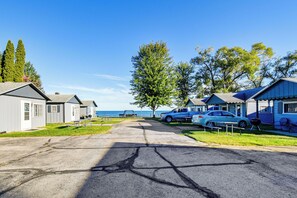 A row of cabins with a view of the water, a paved driveway, and a picnic table. - Quaint Couple’s Unit w/ Lake Access in Tawas City (Tawas City)