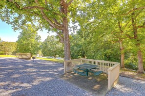 A picnic area with a table and benches, surrounded by trees. - Lake Lure Mtn Getaway w/ Private Balcony (Lake Lure)
