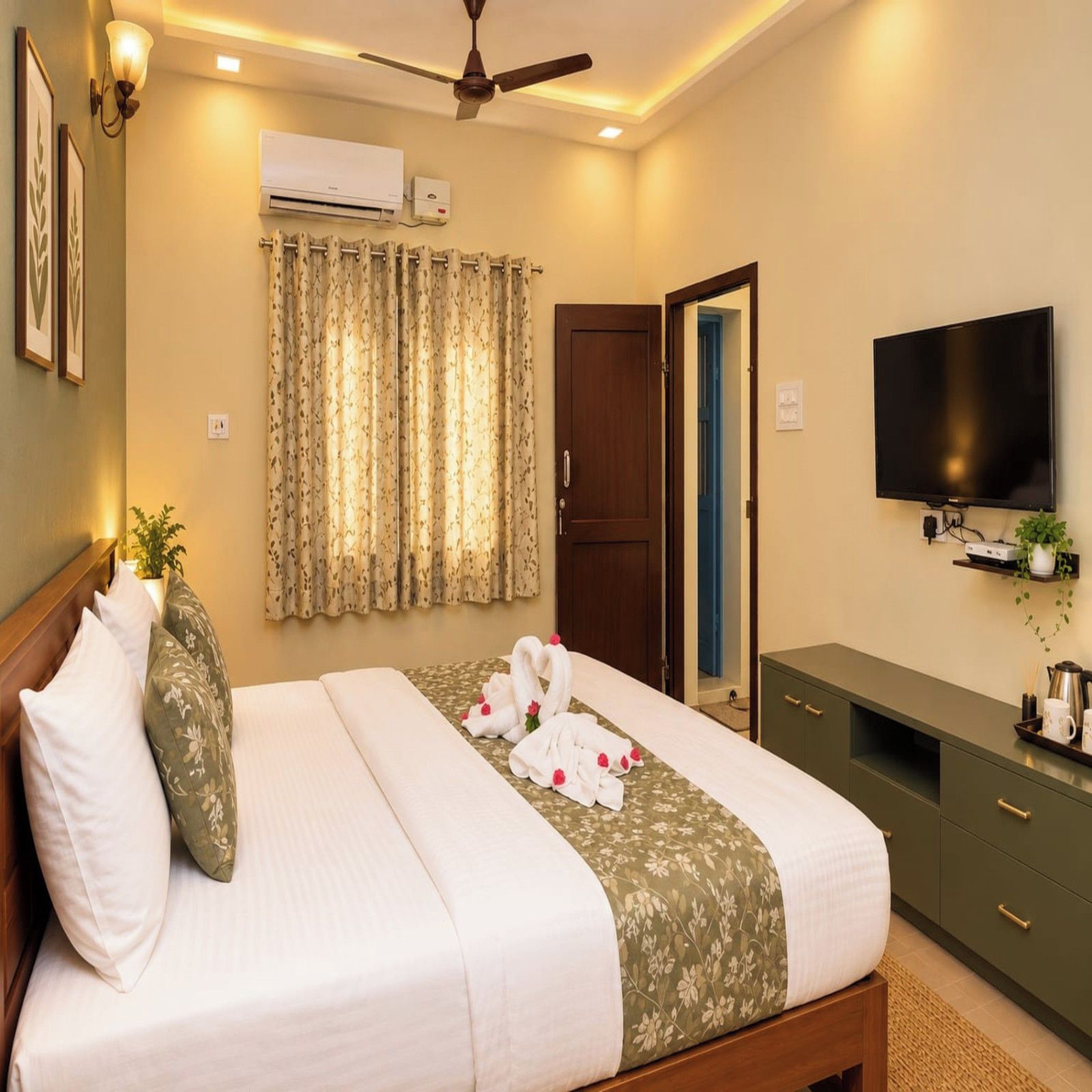 Una habitación de hotel con cama, televisión, escritorio y puerta.
