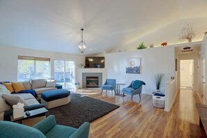 A modern living room with a fireplace, seating area, and a hallway leading to a bathroom. - 3 Mi to Dtwn Bend: Private Hot Tub & Yard (Bend)