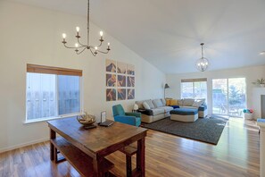 A spacious living area with a wooden dining table, a sofa set, and a chandelier. - 3 Mi to Dtwn Bend: Private Hot Tub & Yard (Bend)