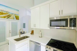 A kitchen with white cabinets, stainless steel appliances, a dishwasher, and a stove. - Naples Guest House Near Beaches & Downtown! (Naples)