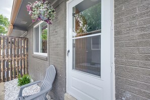 Een huis met een witte deur, een raam en een bloemenmandje.