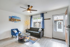 A living room with a sofa, armchair, coffee table, and artwork on the wall. - 2-Condo Hub! 1/2 Mi to University of Dayton (Dayton)