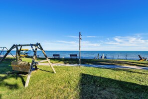 Un parc avec des balançoires, des bancs et une vue sur la mer.