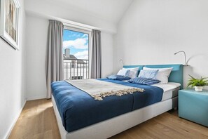 A bedroom with a bed, a nightstand, a potted plant, and a window with curtains. - Apartment in Olpenitz with swimming pool (Olpenitz)