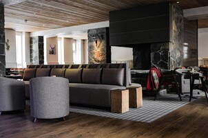 Un salon moderne avec une cheminée en pierre, un canapé et une table basse.