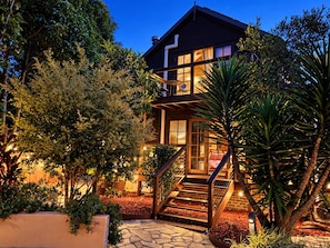 A modern house with a staircase leading to a balcony, surrounded by lush greenery and a stone pathway. - Resort-style Executive and Family Retreat (Hornsby)
