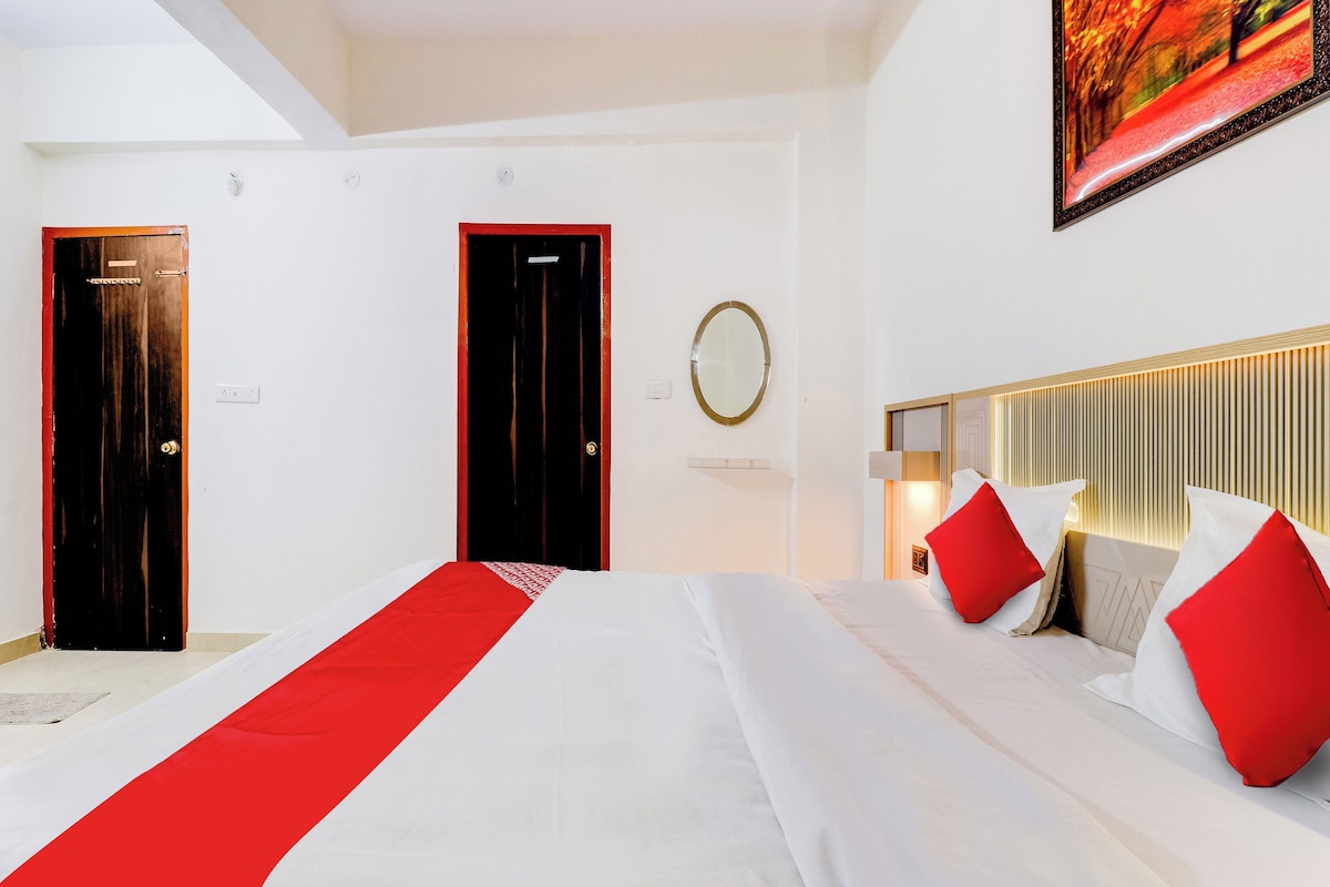 Une chambre d’hôtel avec un grand lit, deux portes, un miroir et un tableau au mur.