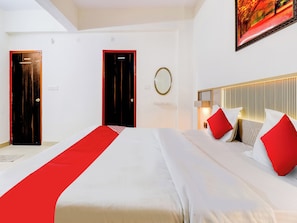 Une chambre d’hôtel avec un grand lit, deux portes, un miroir et un tableau au mur.