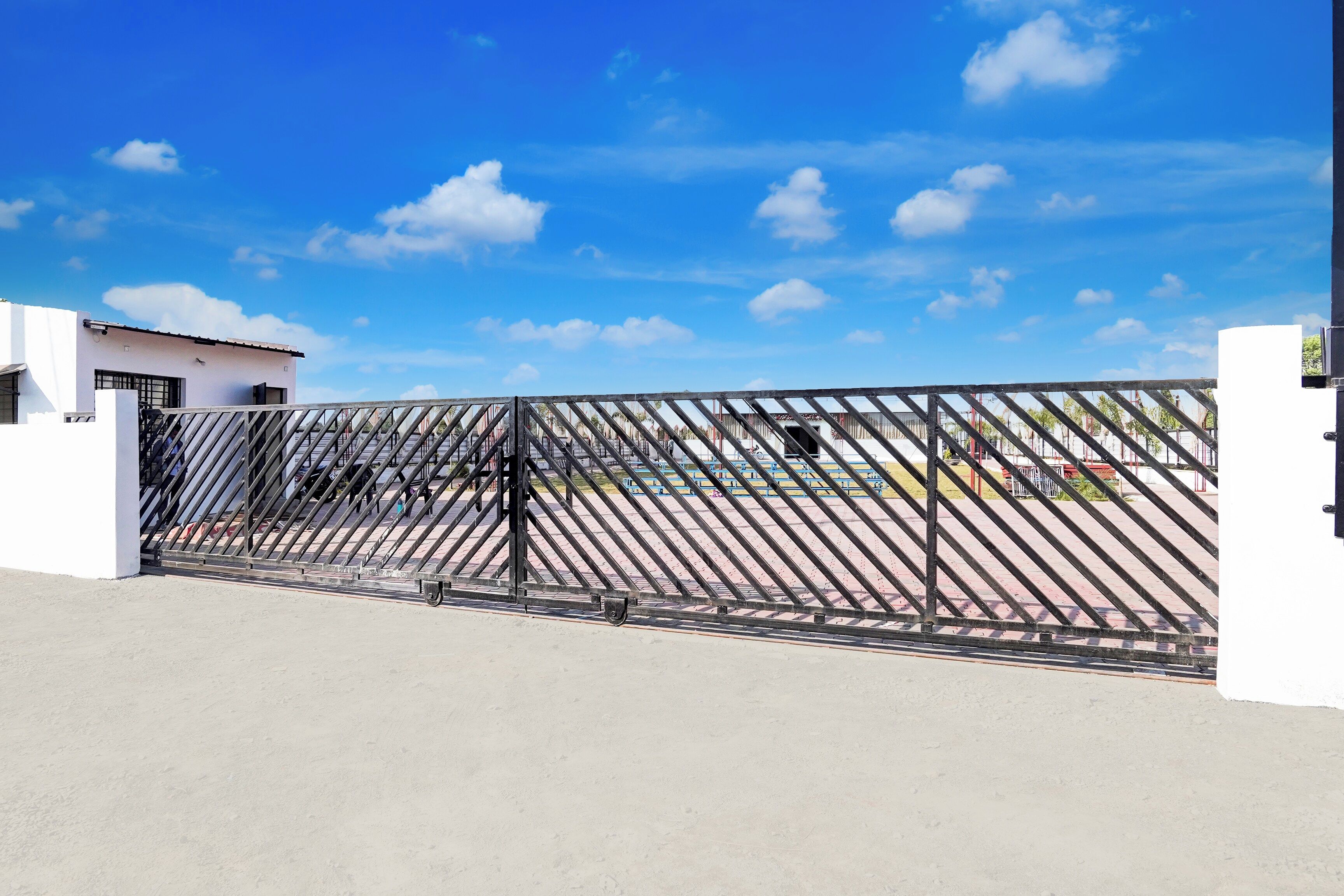 Un espace clos, avec un ciel dégagé et un bâtiment en arrière-plan.