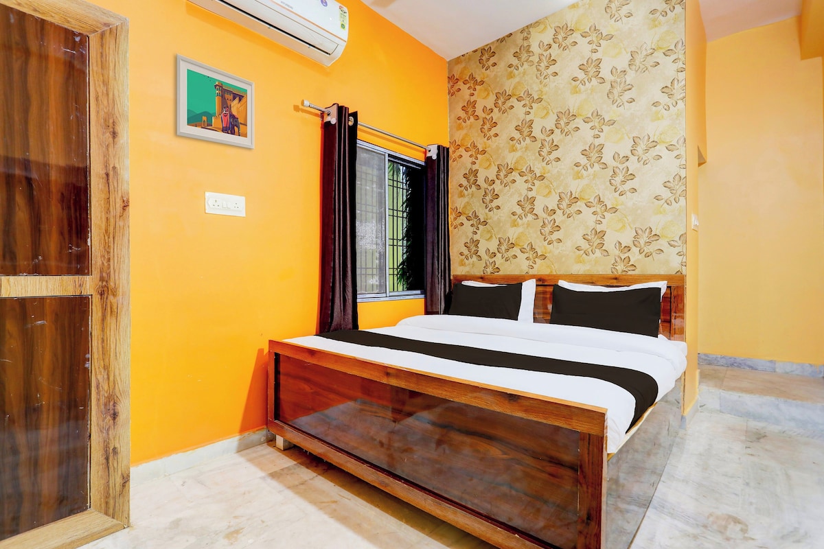 Una habitación con una cama, una ventana con cortinas, un aire acondicionado instalado en la pared y una puerta.