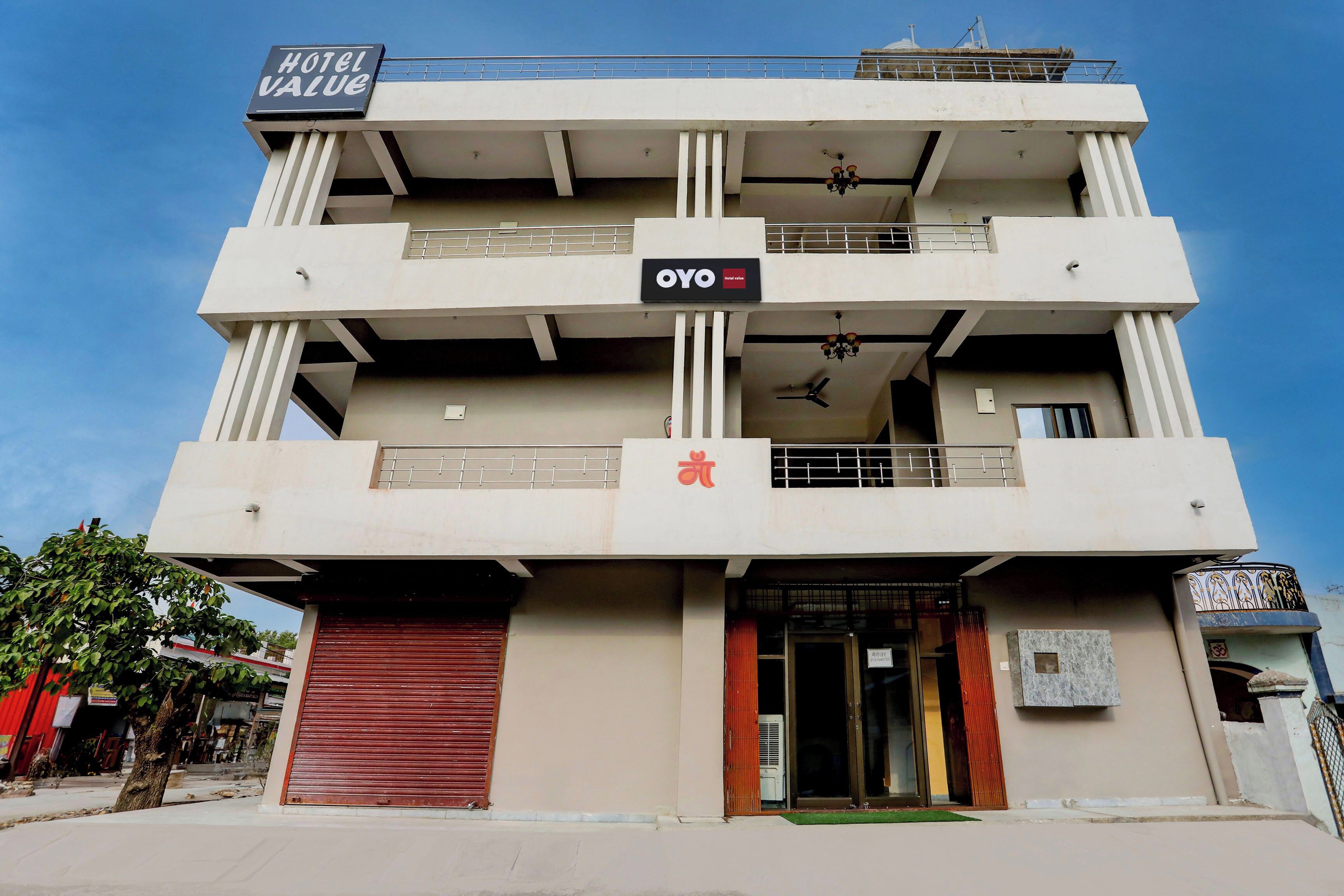 Un hôtel à plusieurs étages, avec une enseigne indiquant « Hôtel Value » et arborant la marque « OYO ».