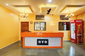 A reception desk with a sign reading 'OYO' and a Coca-Cola refrigerator. - Hotel O by OYO Value (Jabalpur)