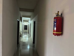 A corridor with a fire extinguisher mounted on the wall.