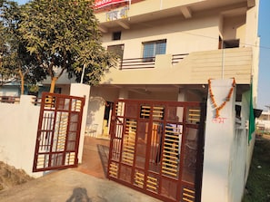 A residential building with a gated entrance, a balcony, and a tree in front. - Hotel O CityMax (Jabalpur)