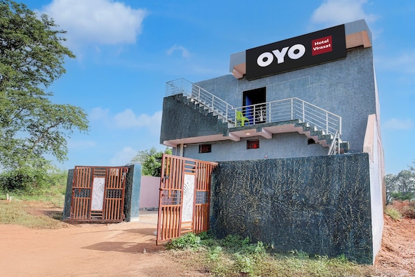 A building with a sign reading 'OYO Hotel Virasat' and a staircase leading to an upper level.