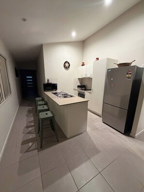 A compact kitchen with a central island, a refrigerator, and a microwave. - Luxurious family home away from home, comfortable (Park Ridge)