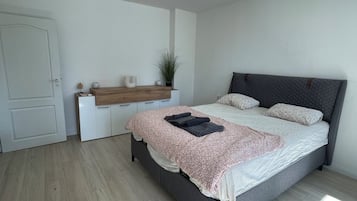 A bedroom with a bed, bedside table, and a door.