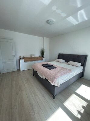 Une chambre à coucher avec un lit, une table de chevet et une porte.