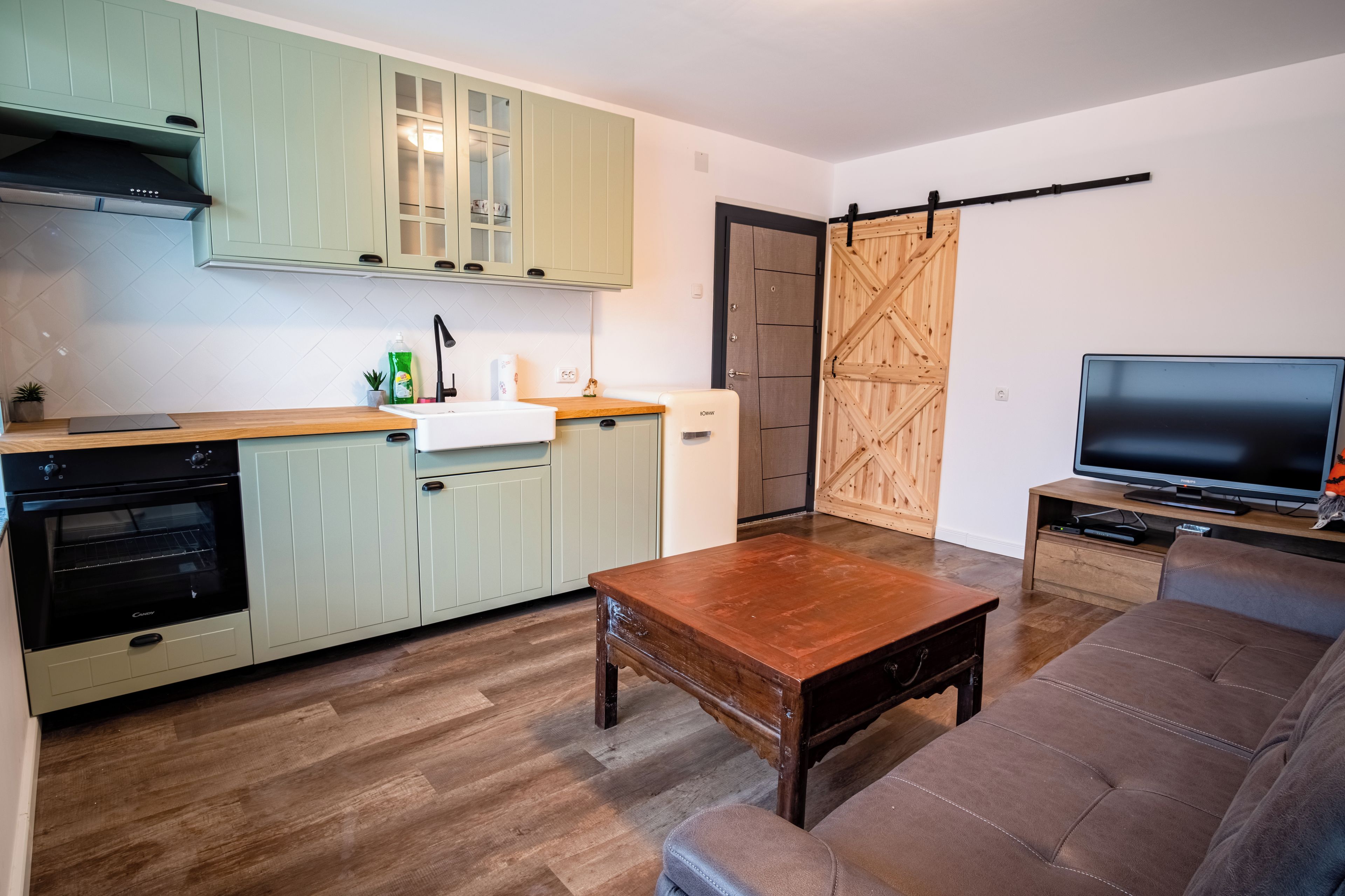 Um espaço compacto com cozinha compacta, área de refeições e espaço para sentar.